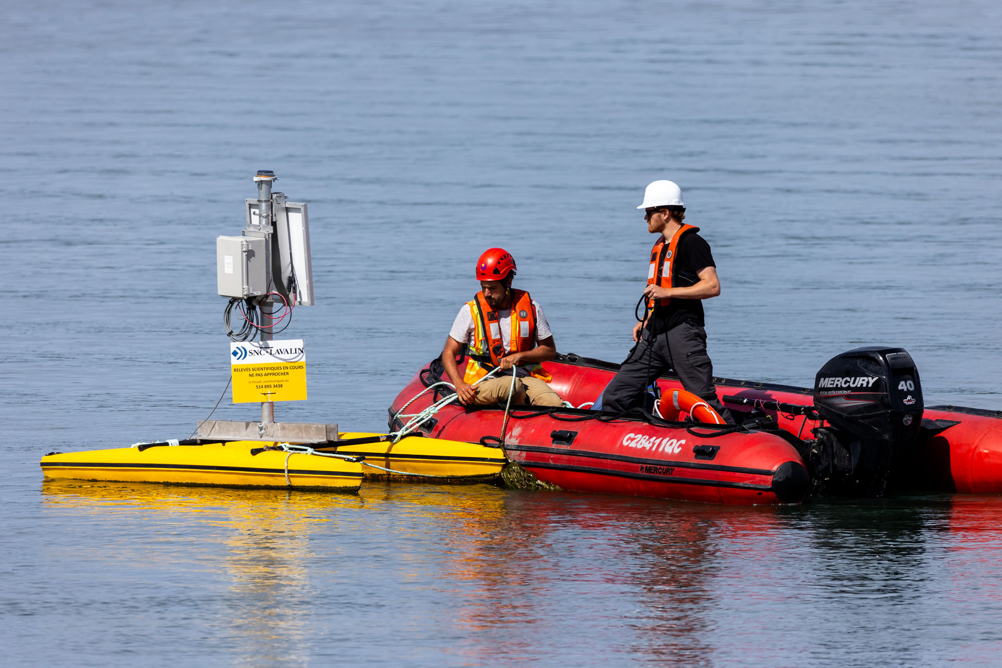 Techniciens inspectant des capteurs de turbidité dans le fleuve Saint-Laurent dans le cadre de l’expansion du Port de Montréal à Contrecœur